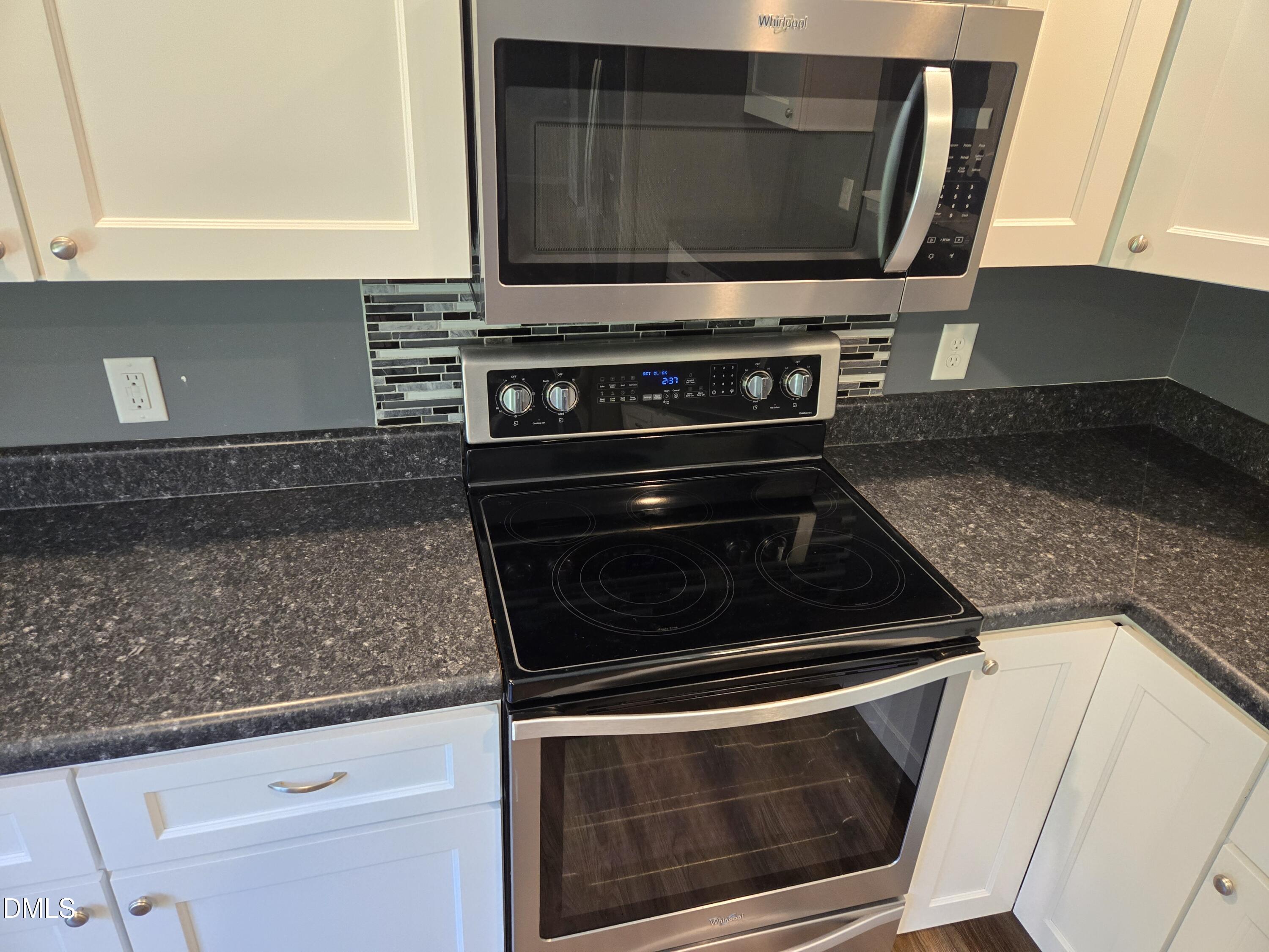 1180 Lambert Chapel Road Siler City, NC 27344 - Photo 31 of 42 a kitchen with granite countertop a stove and a microwave