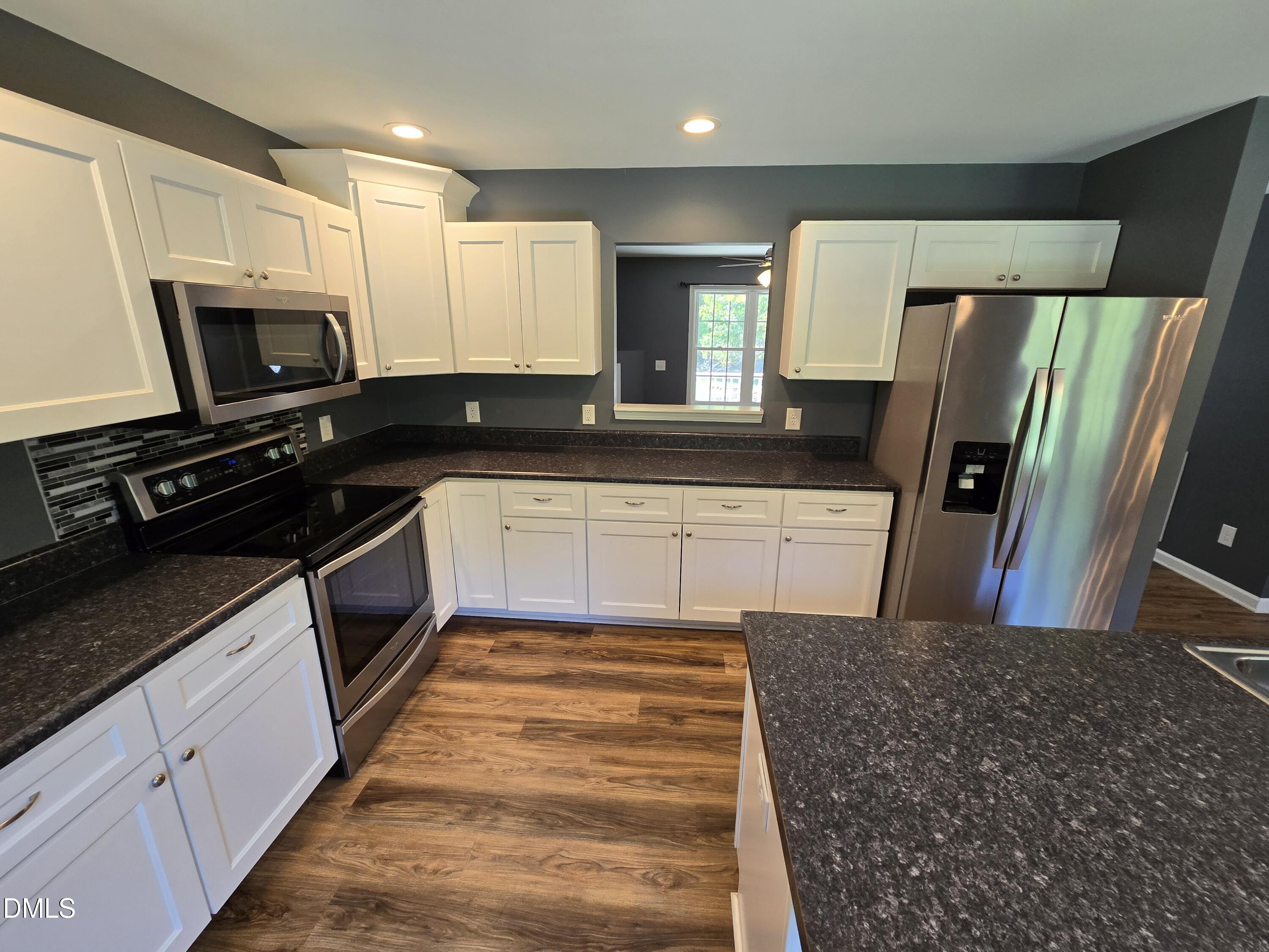 1180 Lambert Chapel Road Siler City, NC 27344 - Photo 32 of 42 a kitchen with stainless steel appliances granite countertop a sink stove and refrigerator