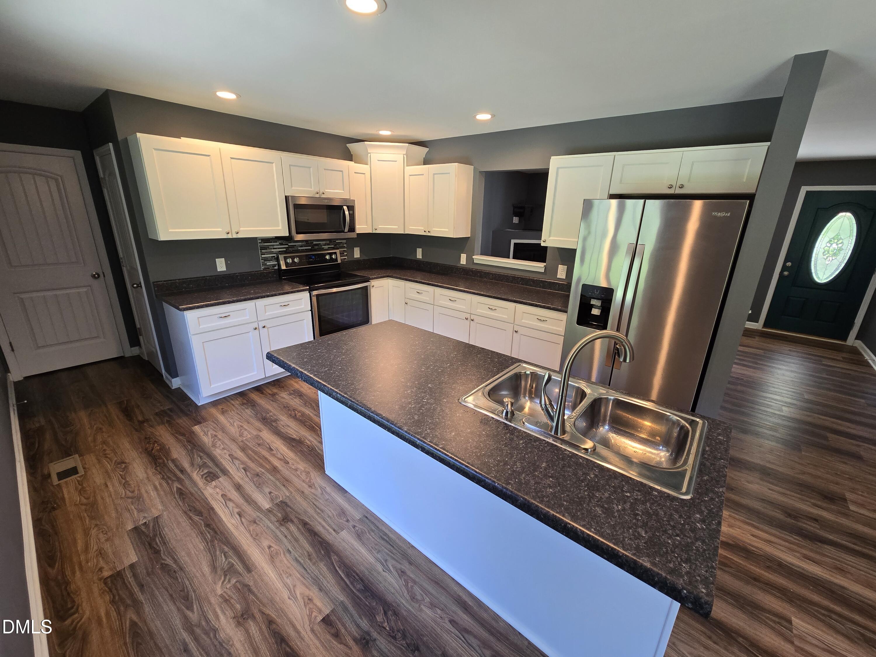 1180 Lambert Chapel Road Siler City, NC 27344 - Photo 33 of 42 a kitchen with stainless steel appliances granite countertop a refrigerator a stove and a wooden floors