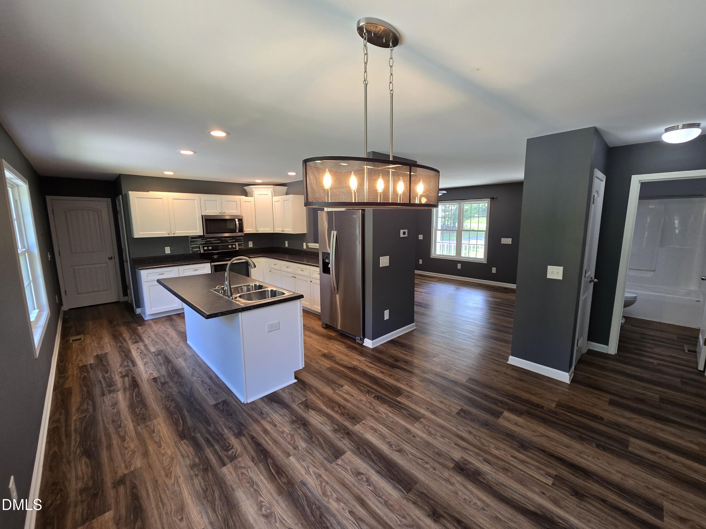 1180 Lambert Chapel Road Siler City, NC 27344 - Photo 34 of 42 a kitchen with refrigerator a stove and wooden floor