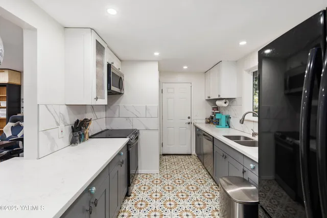 a kitchen with kitchen island a counter space a sink stainless steel appliances and cabinets
