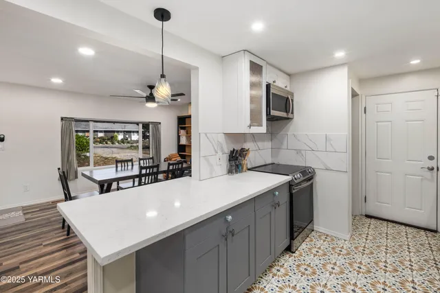 a kitchen with kitchen island a sink appliances and cabinets