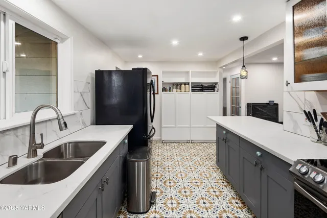 a kitchen with stainless steel appliances granite countertop a refrigerator and a stove top oven