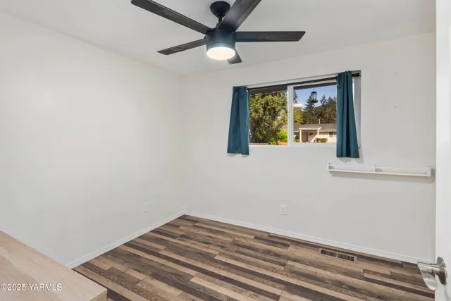 a bedroom with a bed and a chandelier fan