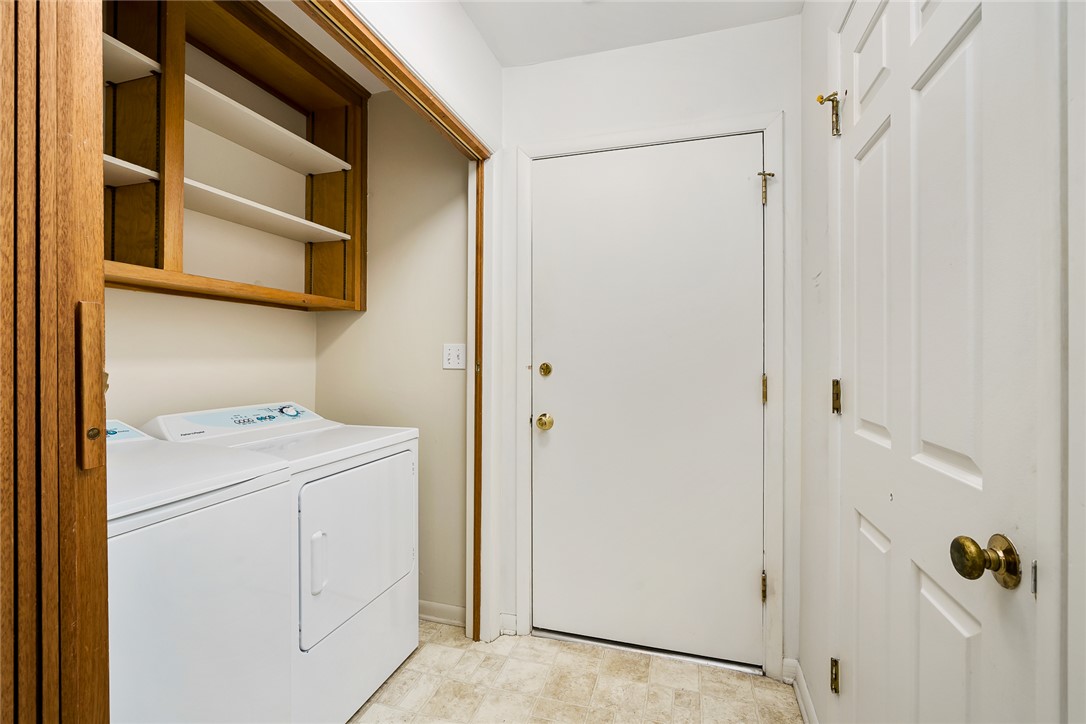34 Hickory Way Clemson, SC 29631 - Photo 25 of 39 Functional laundry area featuring built-in shelving above a washer and dryer unit, providing convenient storage and utility.
