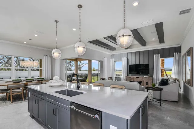 a kitchen with stainless steel appliances granite countertop a sink a stove and a wooden floors