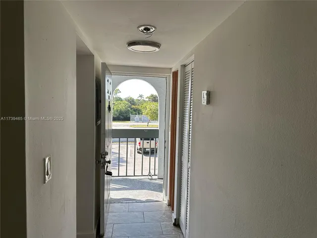 a view of hallway with a large window and front door