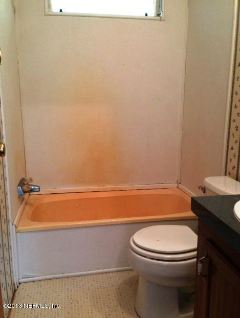 96135 Durden Road Yulee, FL 32097 - Photo 9 of 10 a bathroom with a granite countertop toilet and a bathtub