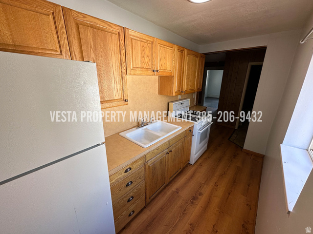 471 East 22nd Street Ogden, UT 84401 - Photo 6 of 12 Kitchen featuring white appliances, light countertops, and wood finished floors