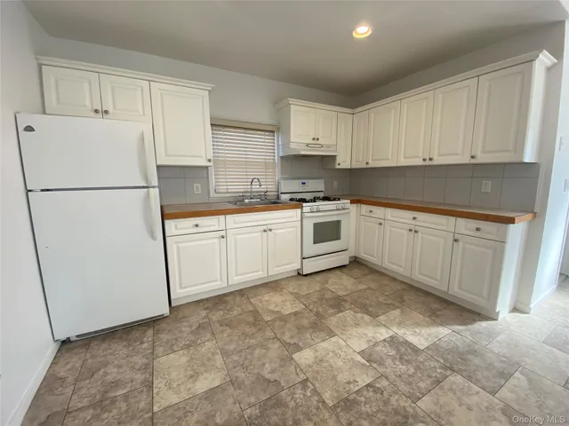 a kitchen with white cabinets and white appliances