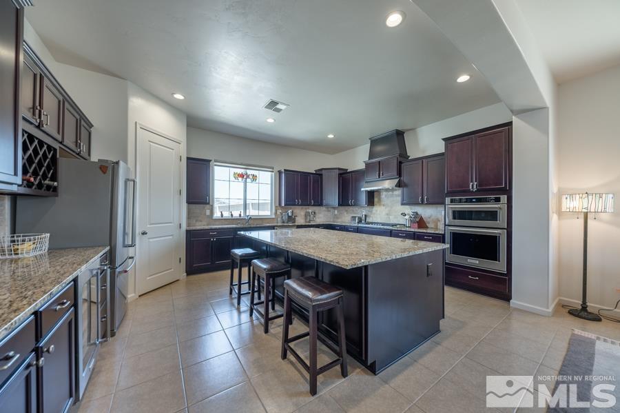 30 Phaethon Court Reno, NV 89521 - Photo 7 of 39 a kitchen with kitchen island granite countertop wooden cabinets a sink a stove a oven and a refrigerator