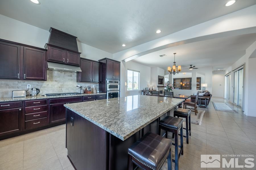 30 Phaethon Court Reno, NV 89521 - Photo 8 of 39 a kitchen with granite countertop a table chairs stove and cabinets