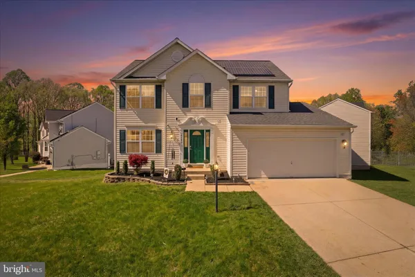 a front view of a house with a garden and yard