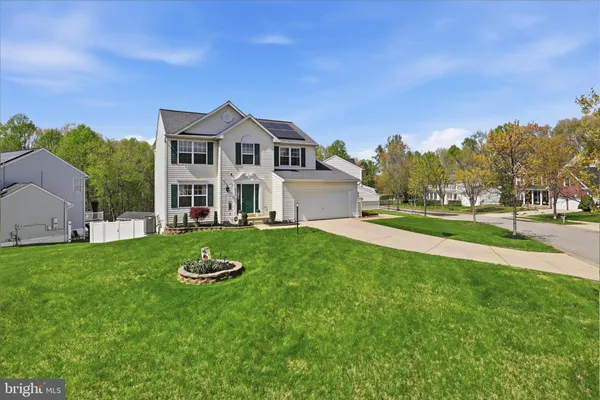 a front view of a house with a yard and trees