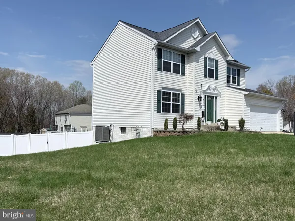 a front view of a house with a garden and yard