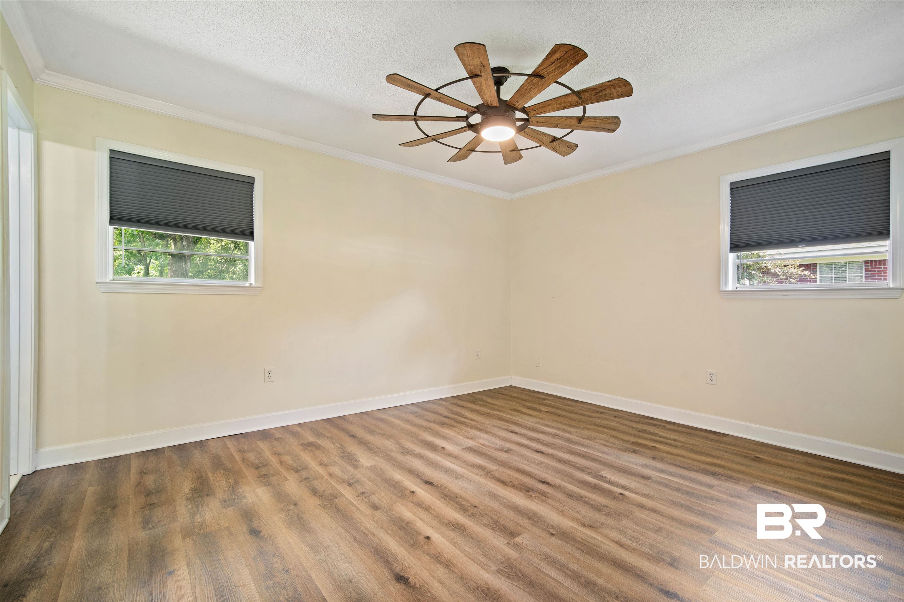 1325 Pawnee Circle Saraland, AL 36571 - Photo 12 of 26 Spare room with crown molding, wood finished floors, ceiling fan, and a textured ceiling