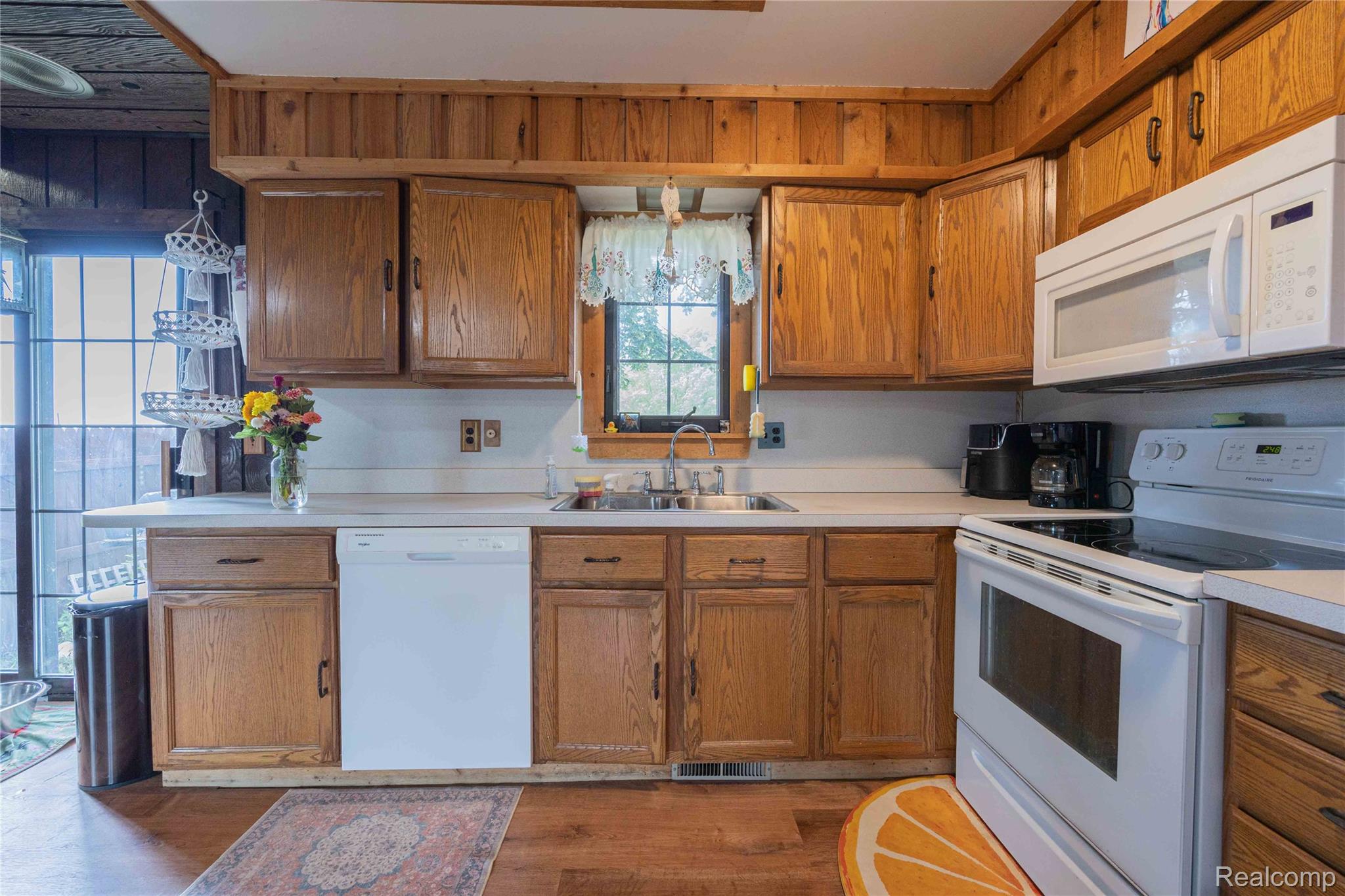 9160 Steffas Road Maybee, MI 48159 - Photo 10 of 36 Wood-finish cabinetry, white countertops, stainless steel sink, white dishwasher, and white electric range with microwave above