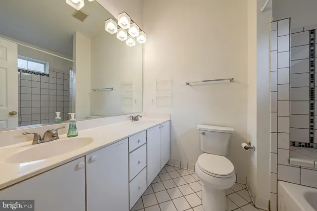 a bathroom with a toilet a sink a mirror and vanity