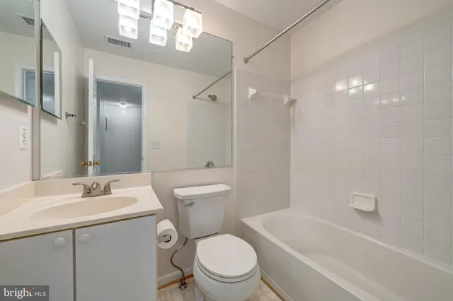 a bathroom with a sink a toilet a mirror and shower