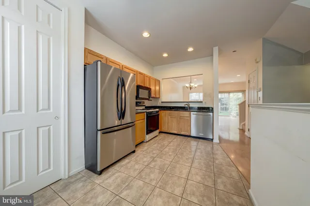 a kitchen with stainless steel appliances granite countertop a refrigerator sink and white cabinets