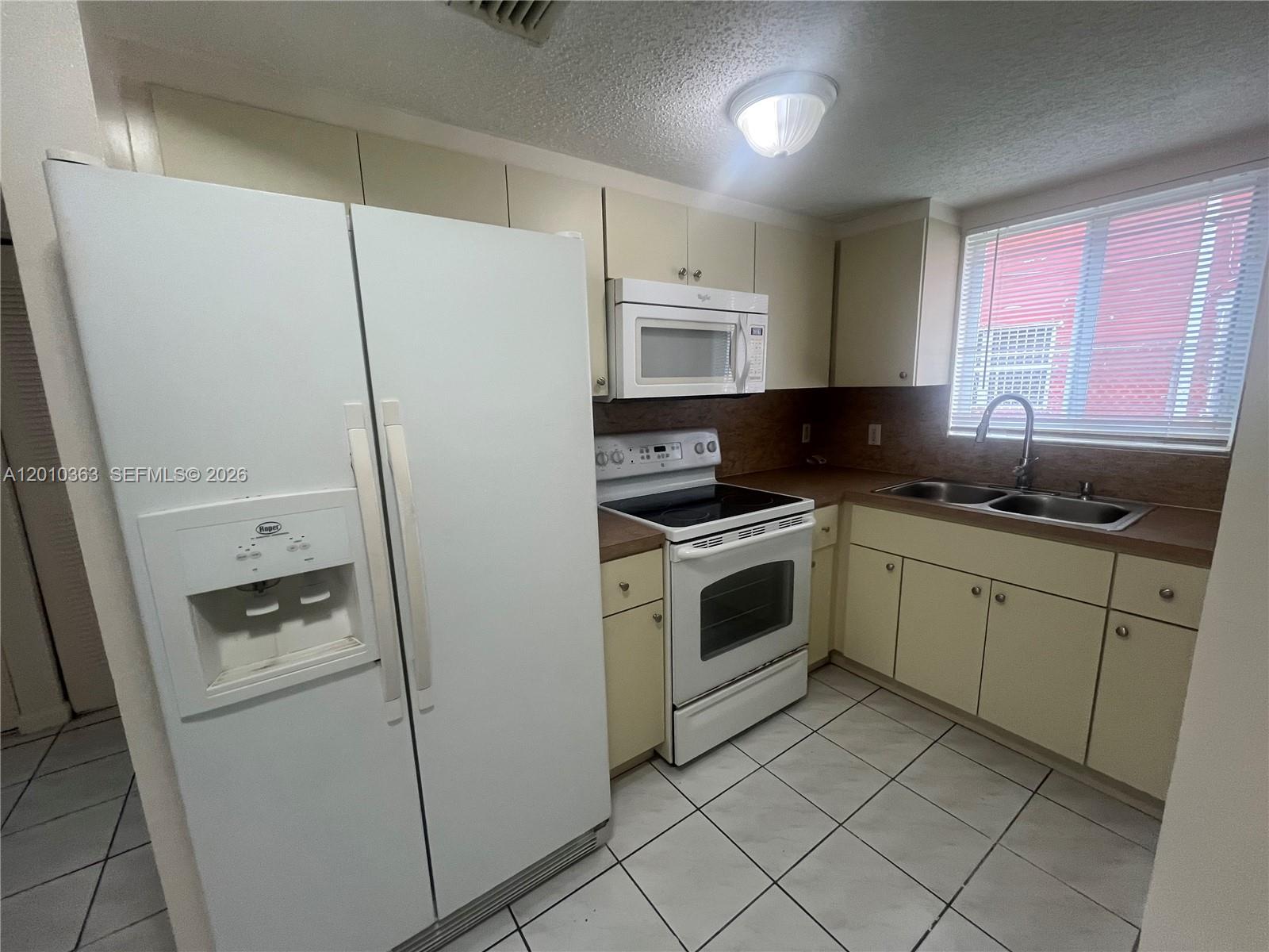 1419 Southwest 22nd Avenue, Unit 4 Miami, FL 33145 - Photo 4 of 11 a kitchen with white cabinets and white appliances