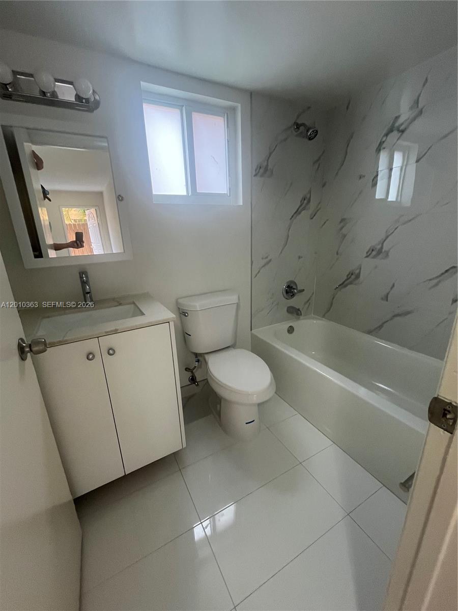 1419 Southwest 22nd Avenue, Unit 4 Miami, FL 33145 - Photo 6 of 11 a bathroom with a granite countertop sink toilet and shower