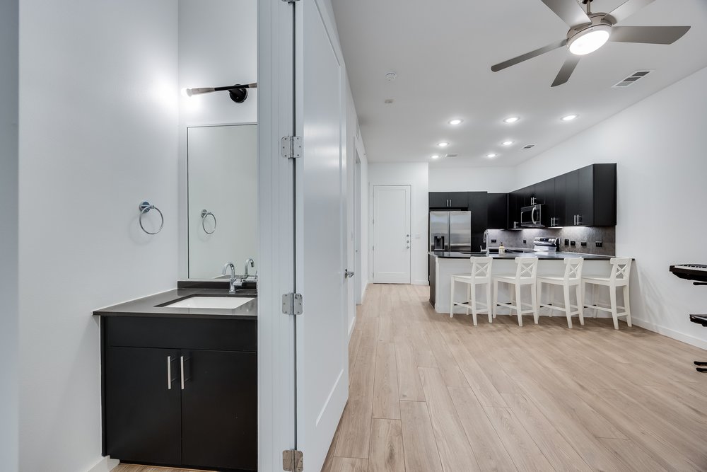 4801 Springdale Road, Unit 2107 Austin, TX 78723 - Photo 12 of 26 a kitchen with a dining table chairs and white cabinets