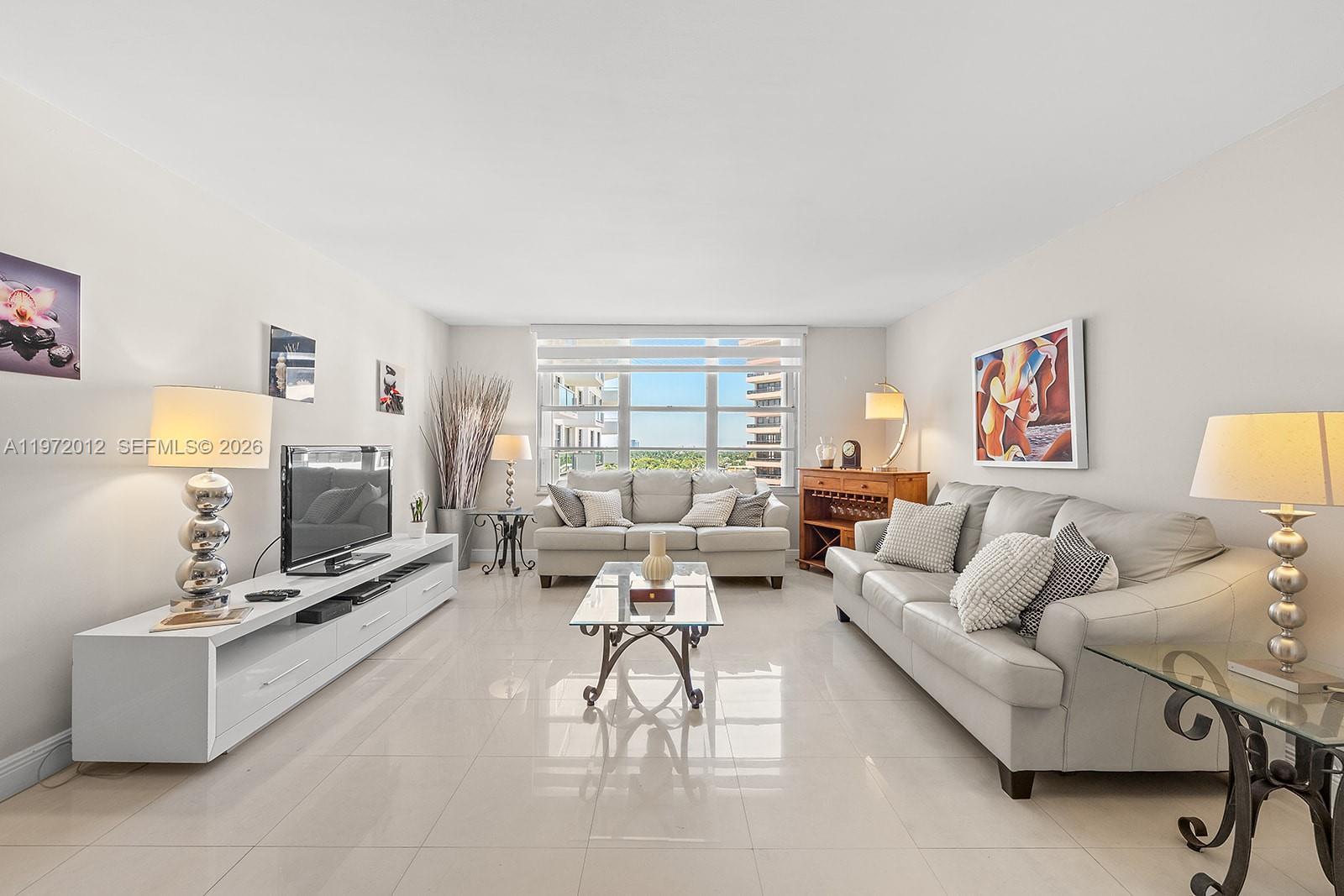 5161 Collins Avenue, Unit 910 Miami Beach, FL 33140 - Photo 4 of 18 a living room with furniture and a flat screen tv