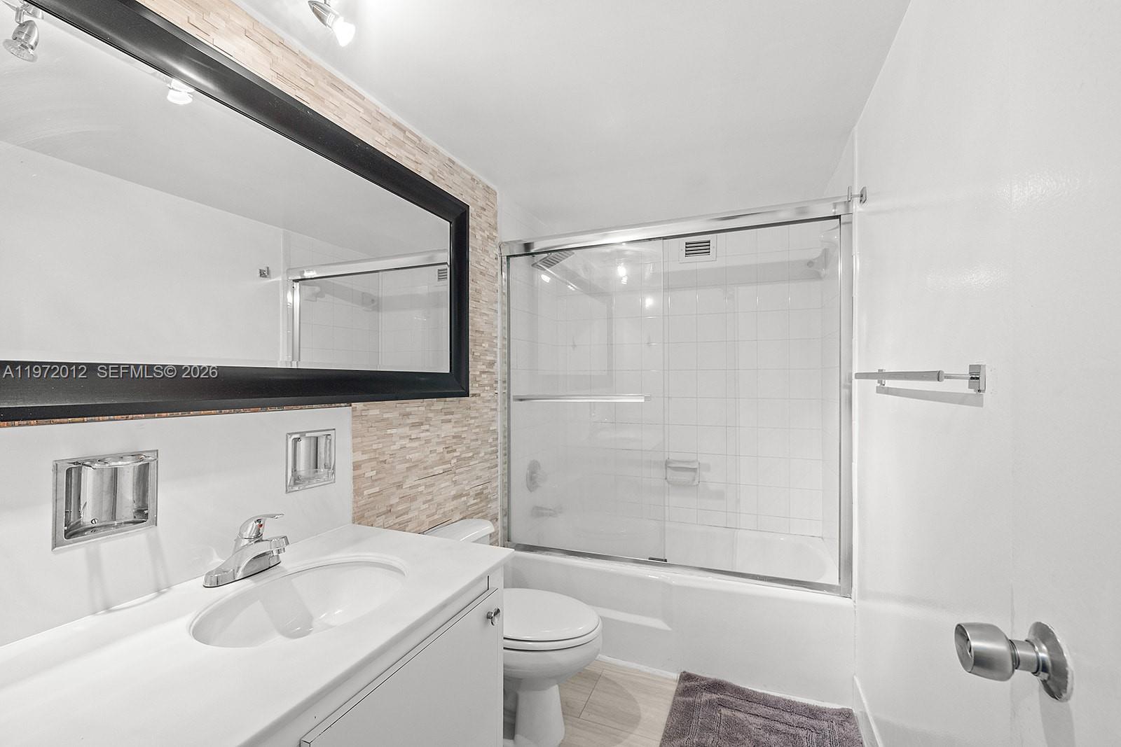 5161 Collins Avenue, Unit 910 Miami Beach, FL 33140 - Photo 10 of 18 a bathroom with a sink toilet and shower