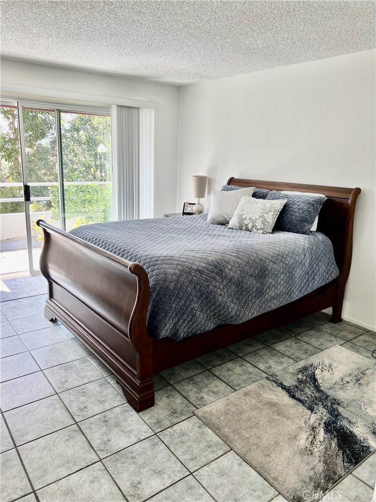 27857 Ruby, Unit 63 Mission Viejo, CA 92691 - Photo 16 of 23 a bedroom with a bed and a large window