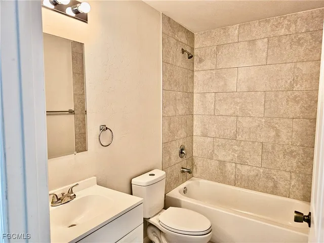 a bathroom with a sink toilet vanity and shower