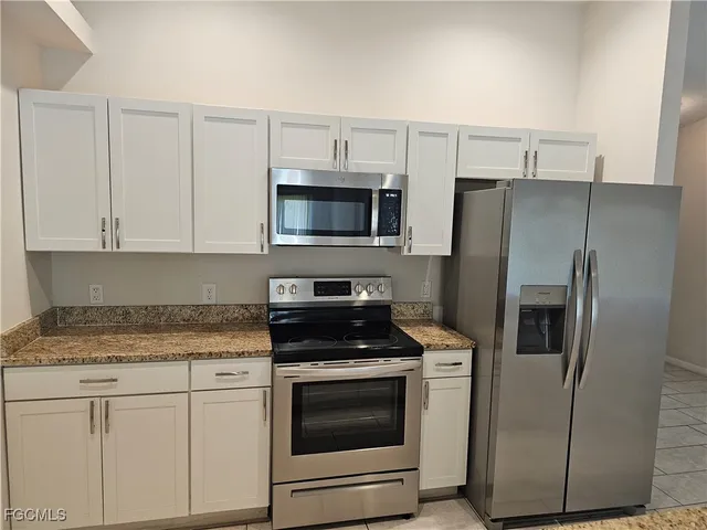 a kitchen with stainless steel appliances white cabinets and a granite counter tops