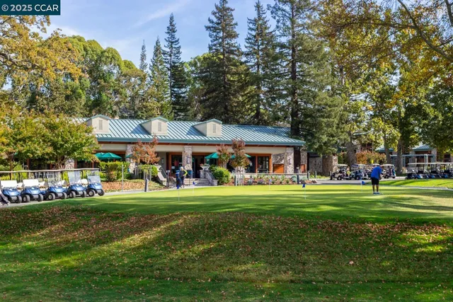 a view of a big house with a big yard and large trees
