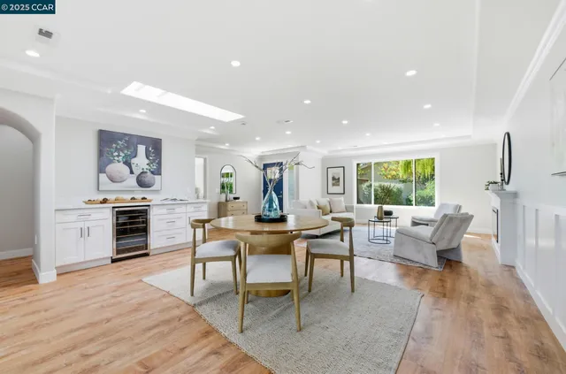 a living room with furniture a large window and wooden floor