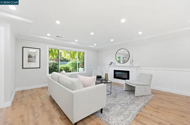 a living room with furniture a fireplace and a large window