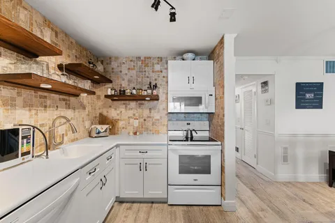 a kitchen with white cabinets and white appliances