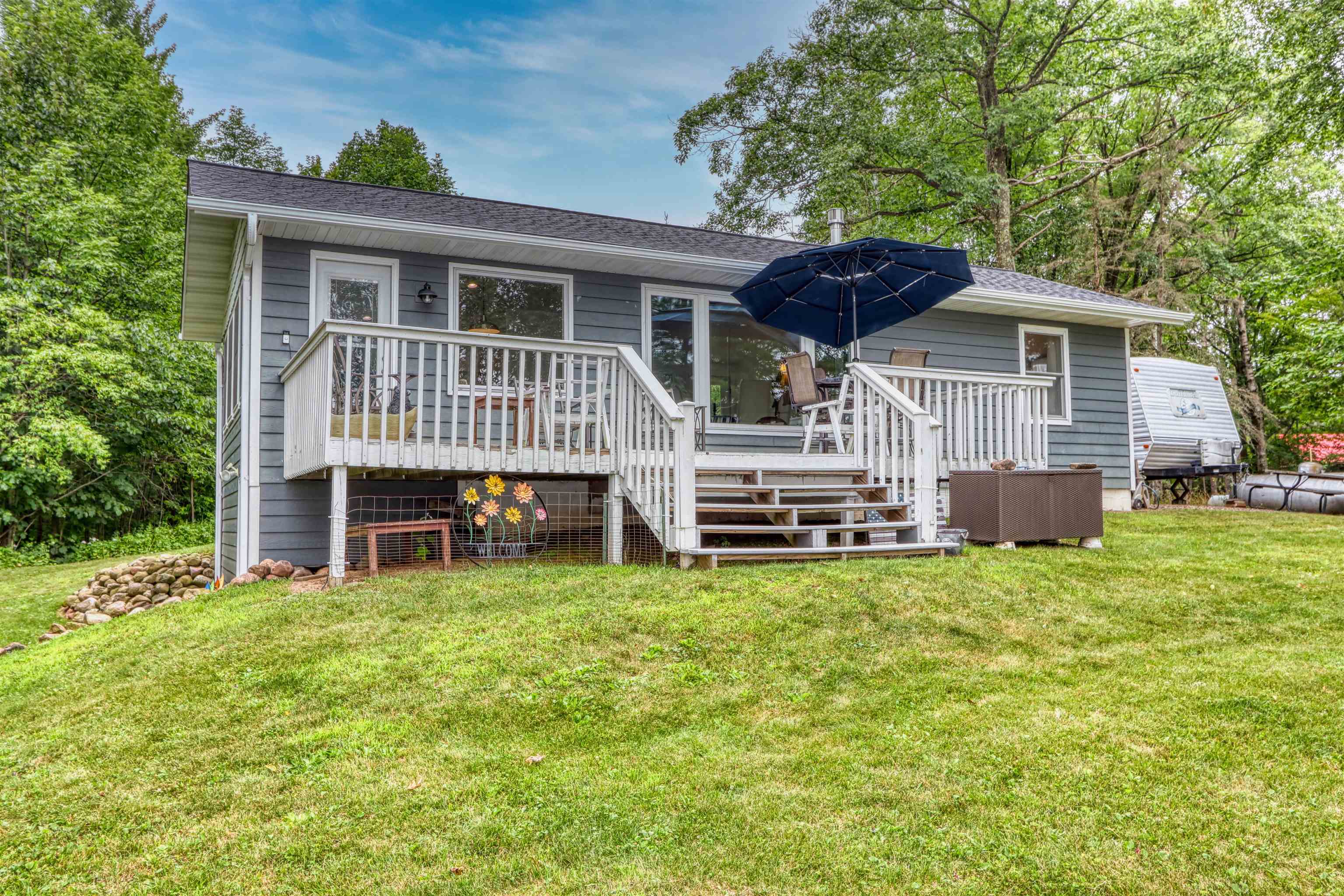 7144 Malm Road Winter, WI 54896 - Photo 51 of 58 Back of property featuring a deck, a lawn, stairway, and a shingled roof
