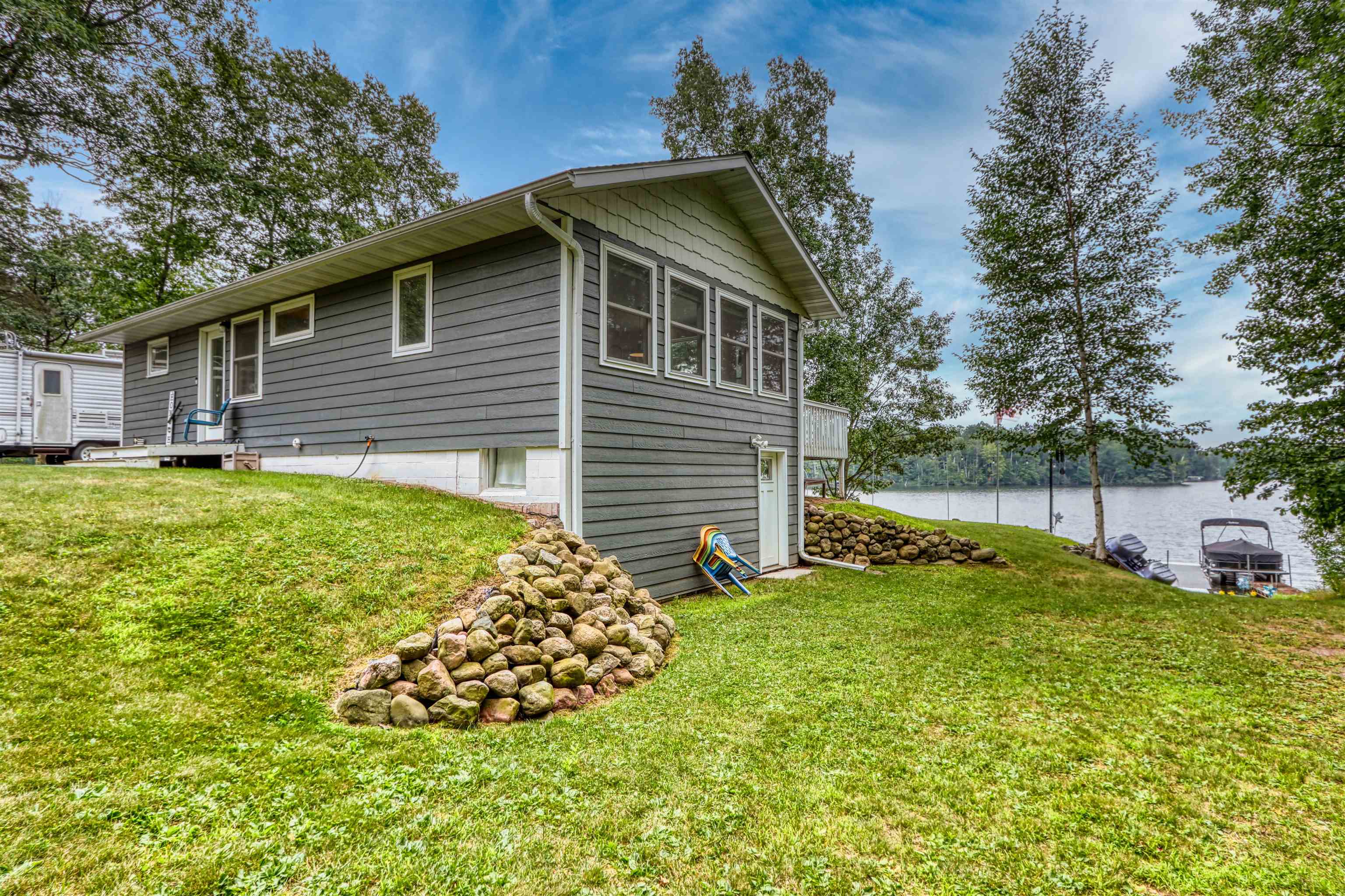 7144 Malm Road Winter, WI 54896 - Photo 7 of 58 View of side of property featuring a lawn and a water view