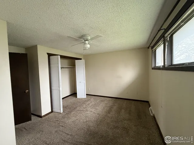 an empty room with windows and closet