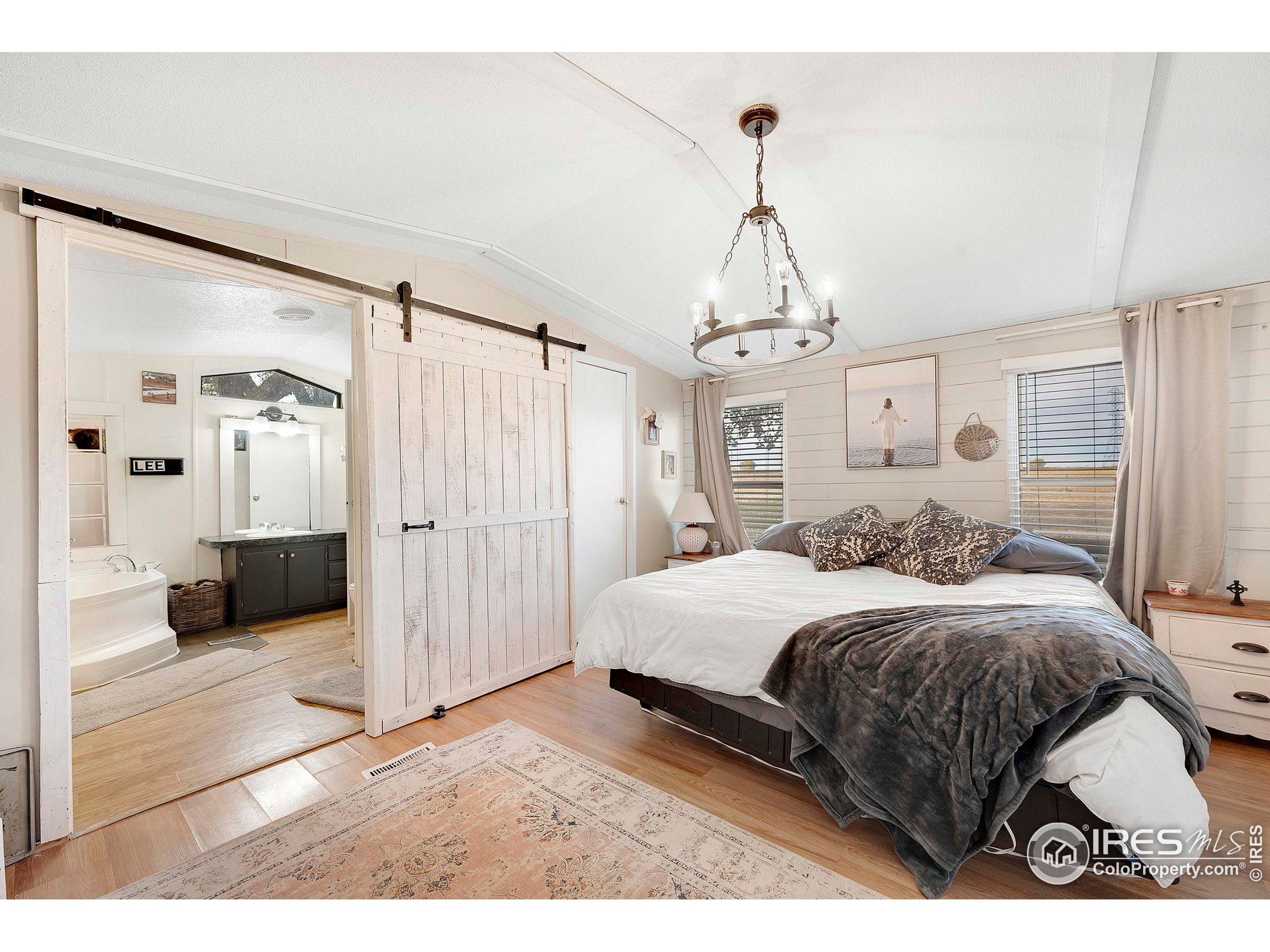9875 County Road 24 Fort Lupton, CO 80621 - Photo 33 of 50 a bedroom with a bed and a walk in closet
