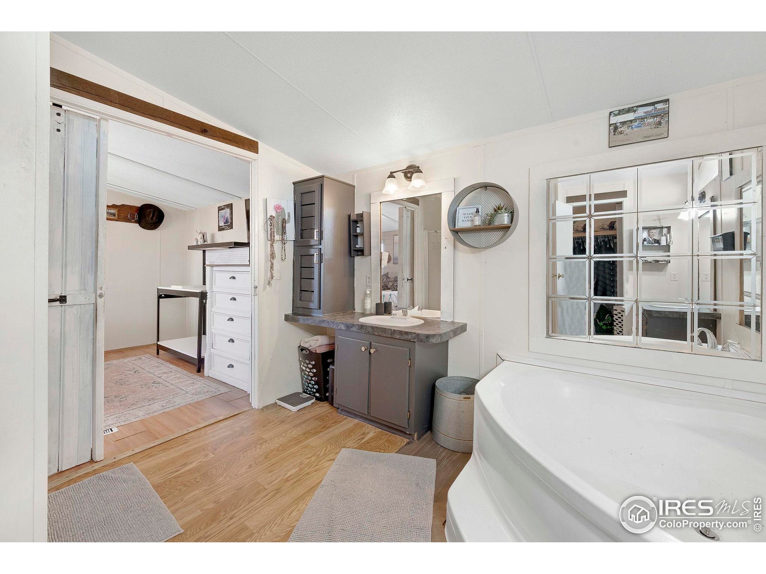 9875 County Road 24 Fort Lupton, CO 80621 - Photo 34 of 50 a room with a bed and a large mirror on the dresser