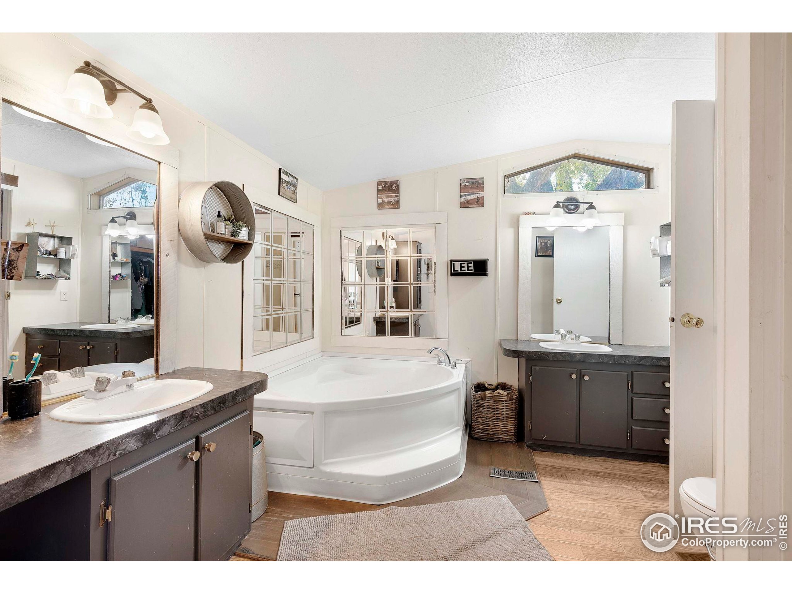 9875 County Road 24 Fort Lupton, CO 80621 - Photo 35 of 50 a spacious bathroom with a granite countertop sink a mirror and bathtub