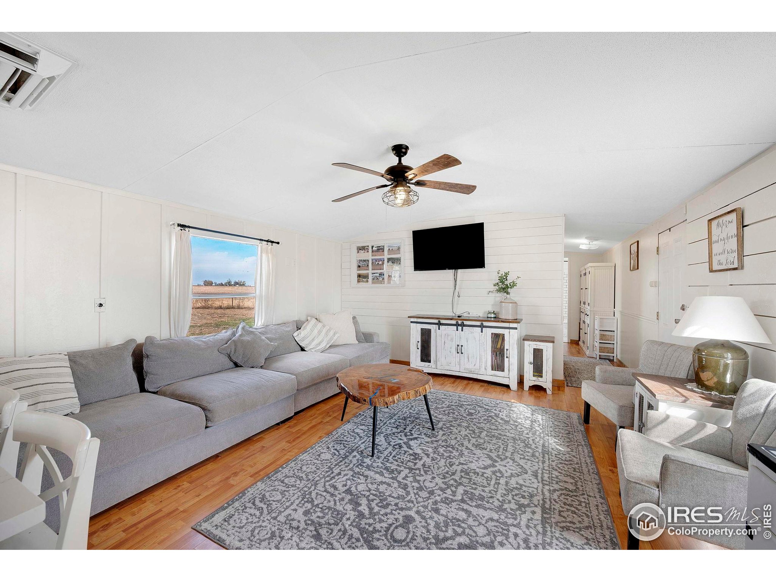 9875 County Road 24 Fort Lupton, CO 80621 - Photo 36 of 50 a living room with furniture and a flat screen tv