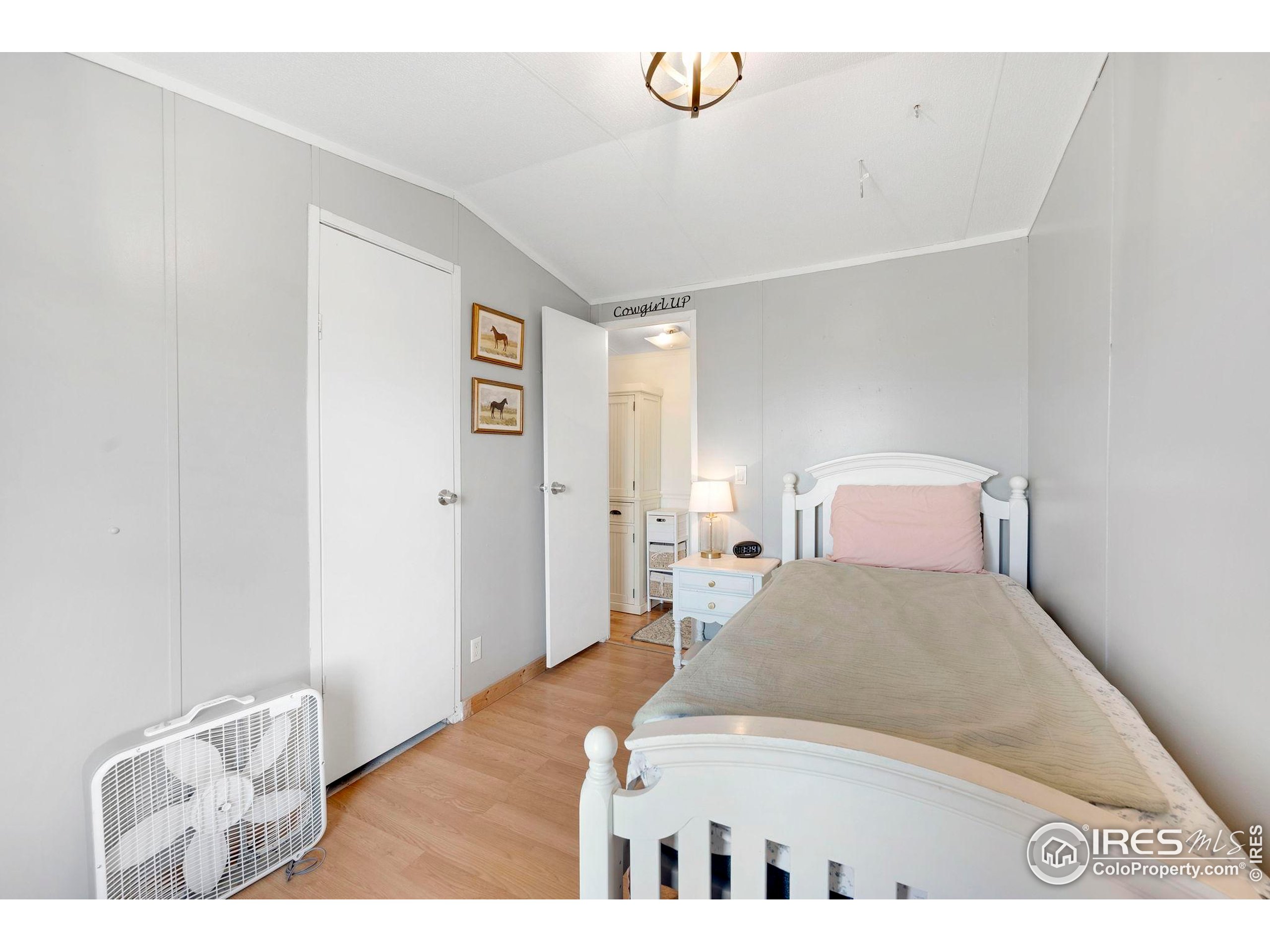 9875 County Road 24 Fort Lupton, CO 80621 - Photo 38 of 50 a bedroom with a bed and a view of kitchen