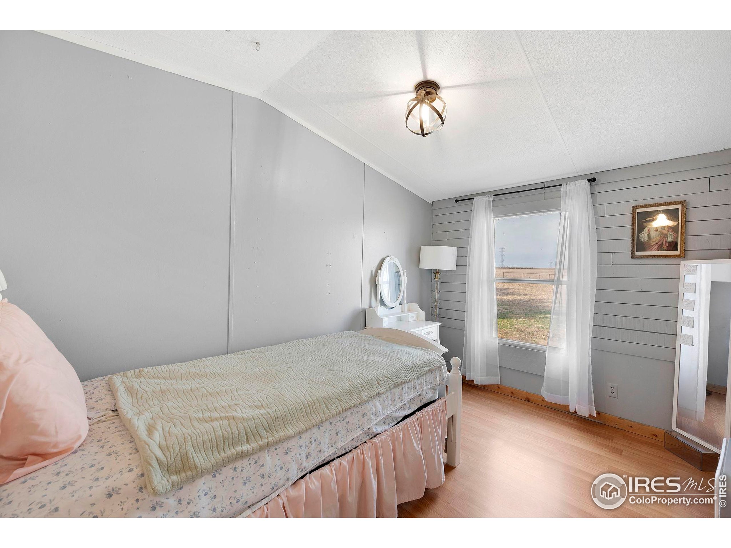 9875 County Road 24 Fort Lupton, CO 80621 - Photo 39 of 50 a bedroom with a bed and a chandelier