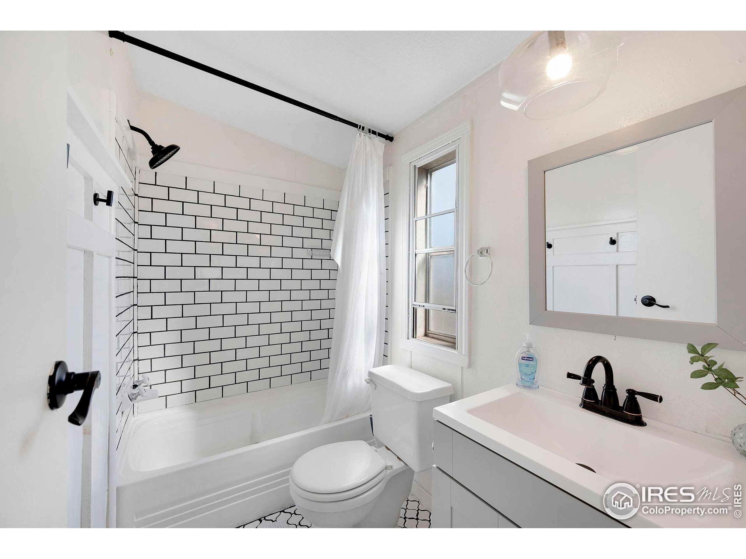 9875 County Road 24 Fort Lupton, CO 80621 - Photo 42 of 50 a bathroom with a sink toilet a mirror and shower