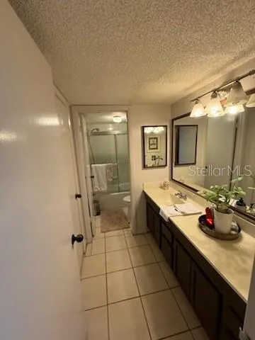 a spacious bathroom with a granite countertop sink mirror and shower