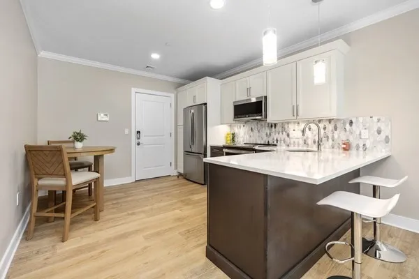 a kitchen with kitchen island a appliances dining table and chairs