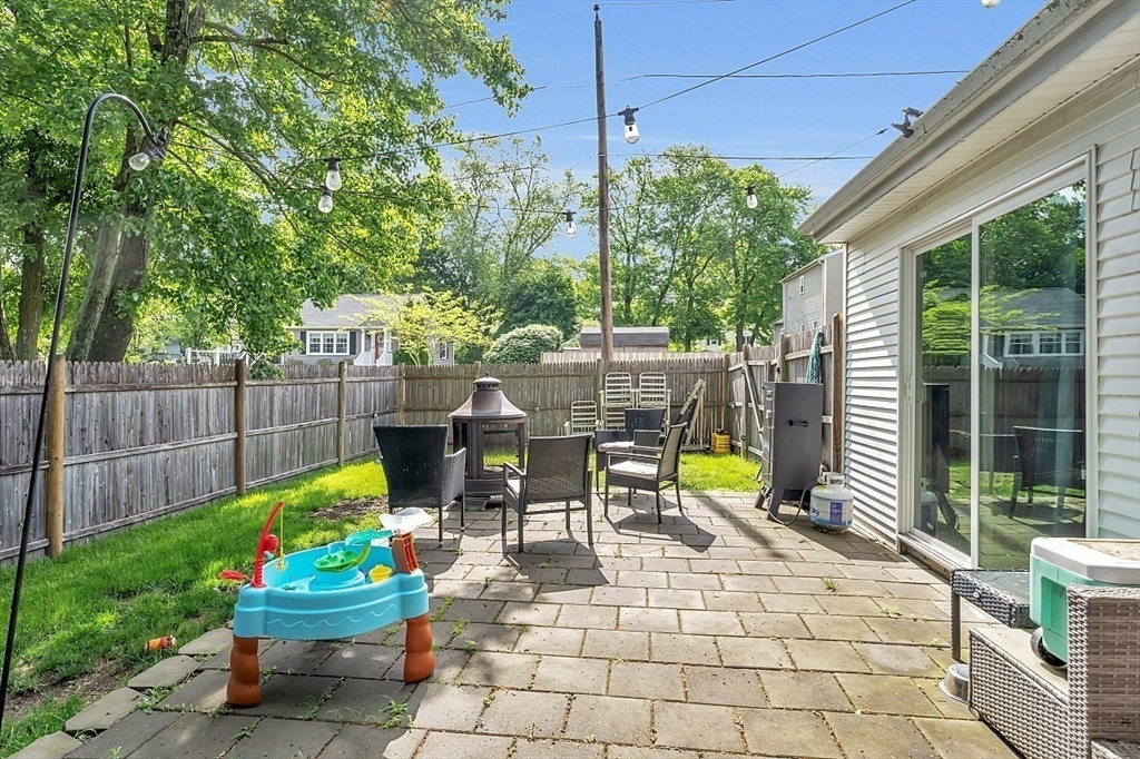898 Boston Road Billerica, MA 01821 - Photo 33 of 38 a view of a patio with a dining table and chairs potted plants and a palm tree