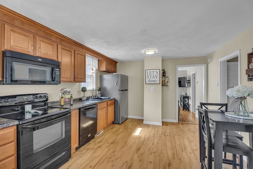 898 Boston Road Billerica, MA 01821 - Photo 10 of 38 a kitchen with stainless steel appliances granite countertop a stove top oven a sink dishwasher a refrigerator and cabinets with wooden floor